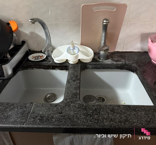 משטח שיש כהה במטבח עם שני כיורים בהתקנה תחתונה